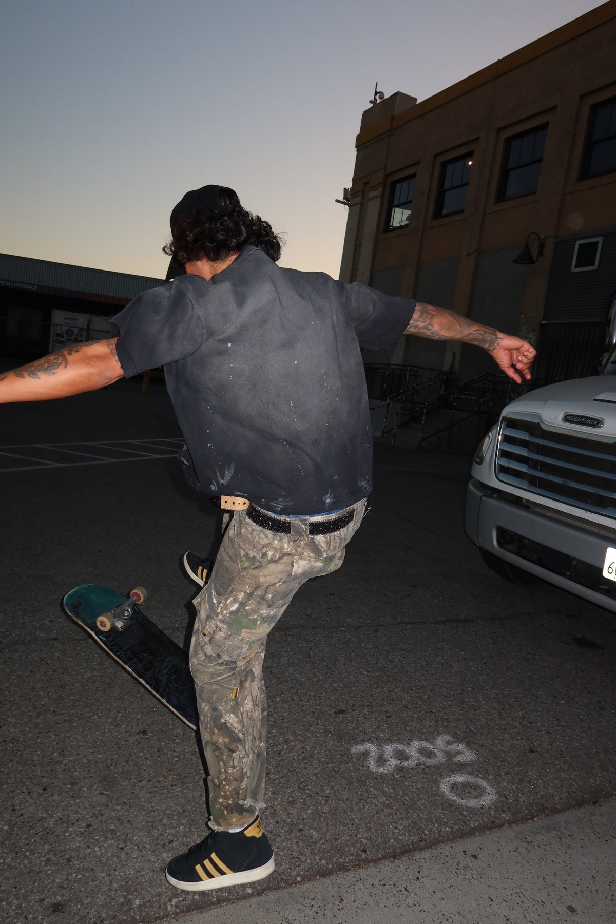 Black Logo — Distressed Tee — Black, back view on model showing faded wash and distressed details