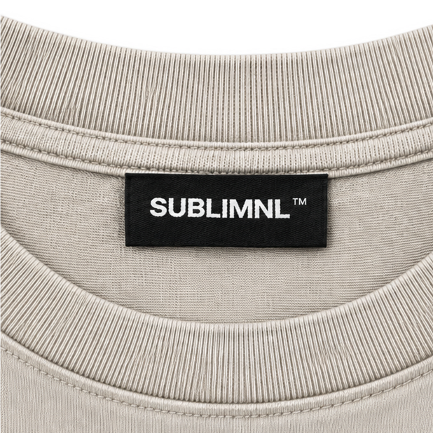 Tan / Black Print — SUBLIMINAL Distressed Tee, neck tag detail